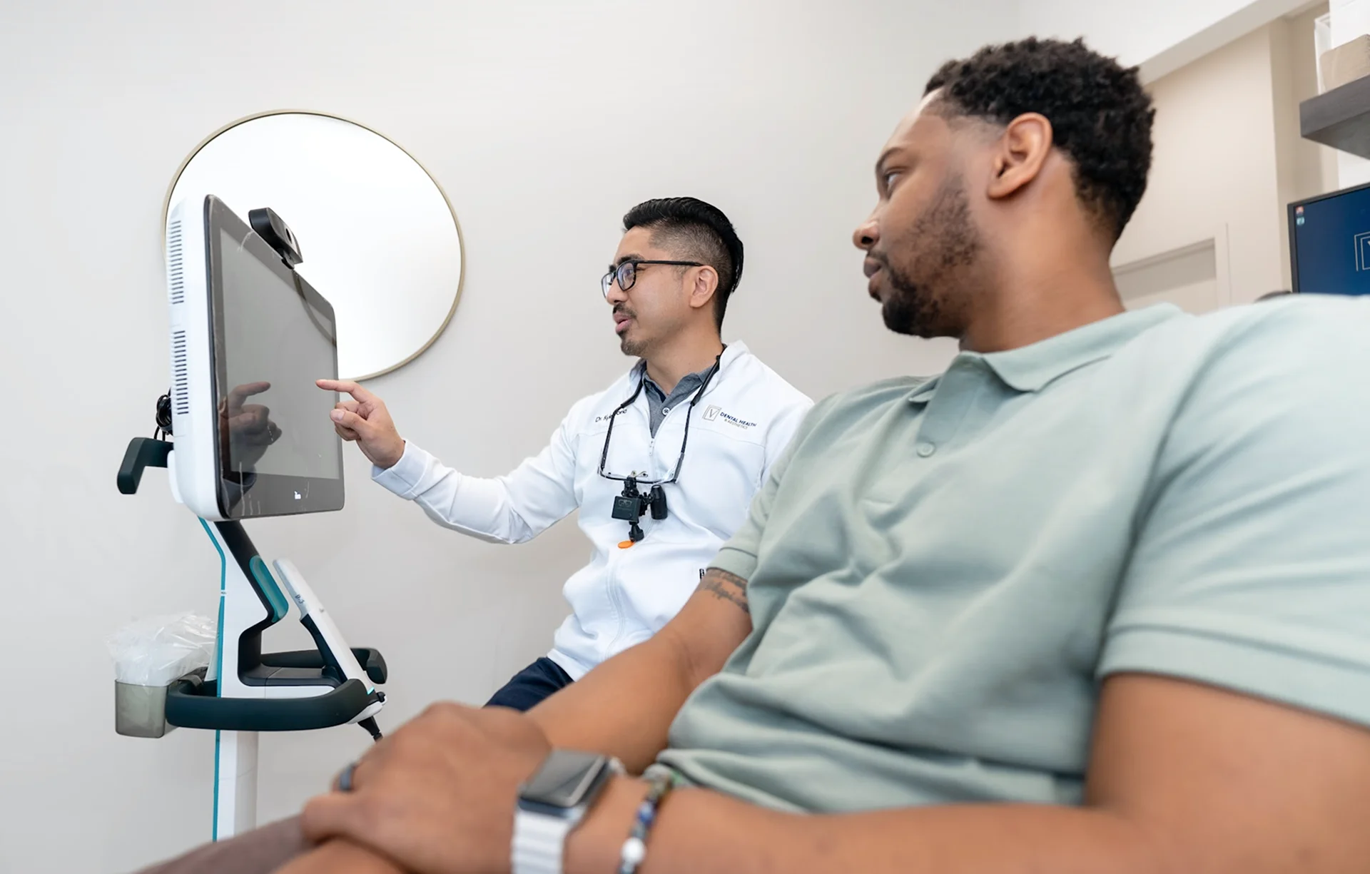 Dentist discussing a digital dental scan with a patient during a consultation.